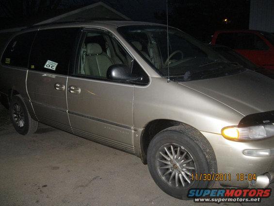 Tan minivan, 3/4 front view. Sticker on driver's door reads 'OC'