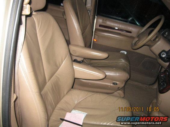 Tan leather interior with captain's chairs and steering wheel