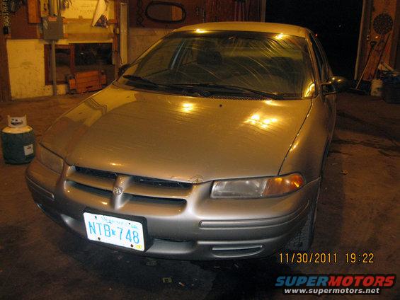 Silver sedan with a dent on the hood, facing forward. License plate NTB 748 is visible