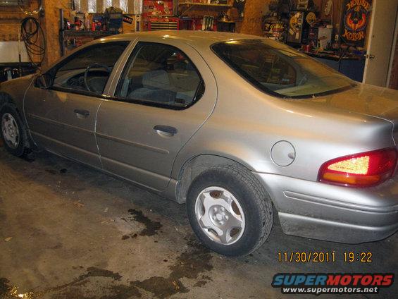 Silver sedan, rear 3/4 view, parked indoors