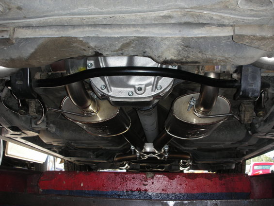 Underside view of a rear differential with dual exhaust mufflers and pipes