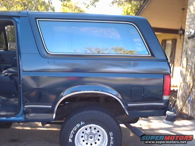 Dark blue SUV side view, showing rear quarter panel and tire with 'FUTURA' text