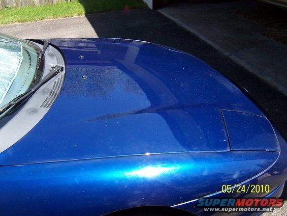 blue car hood with pop-up headlight cover visible