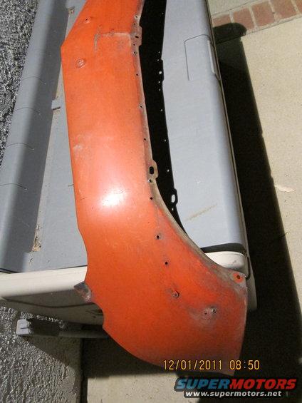 Orange fender part with visible mounting holes and some rust