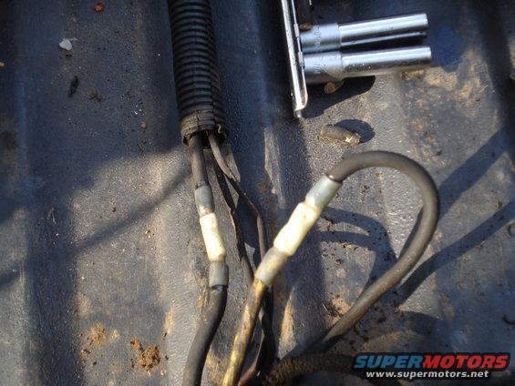 Close-up of engine wiring harness with electrical tape and a set of socket wrenches