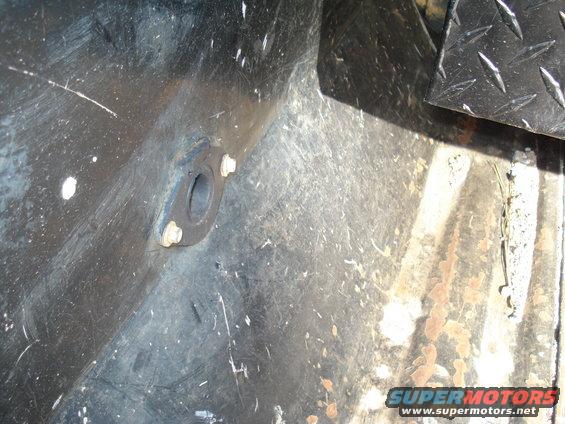 Close-up of a metal bracket with bolts, likely from a truck's undercarriage