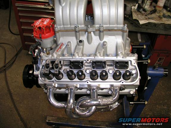 V8 engine with aluminum intake manifold, MSD distributor, and chrome headers, mounted on an engine stand