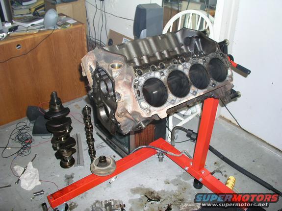 Engine block on stand with crankshaft and camshaft nearby