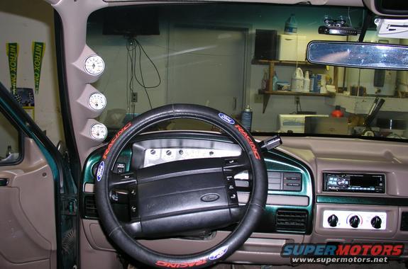 Green 1996 Ford Bronco interior with aftermarket gauges and a Ford Racing steering wheel cover