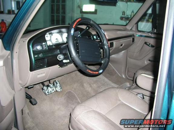 1996 Ford Bronco interior, tan leather seats, dashboard with gauges, steering wheel with racing logo