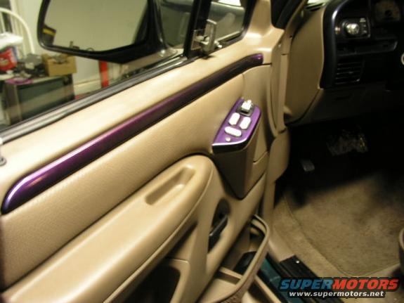 Interior door panel with purple trim and power window controls