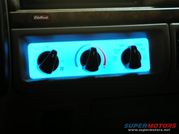Interior climate control knobs with blue backlighting and an Edelbrock badge above