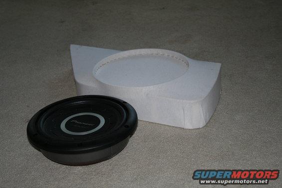 Subwoofer and white enclosure on carpet. Text 'Pioneer' visible on subwoofer