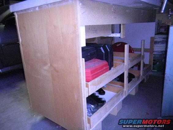 Workbench with red and black toolboxes on shelves