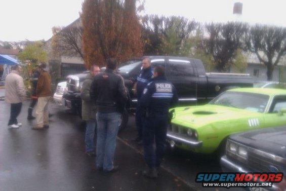 Lime green muscle car with hood scoop and side vents, parked next to a black pickup truck