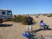 1988 Ford Bronco - A group gathers in a desert landscape with RVs and other vehicles present under a clear blue sky.