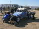 1988 Ford Bronco - A group of people are gathered around a blue off-road buggy, appearing to perform maintenance or repairs.