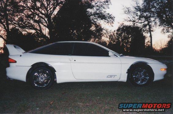 White 1994 Ford Probe GT coupe with tinted windows and a rear spoiler, parked on grass