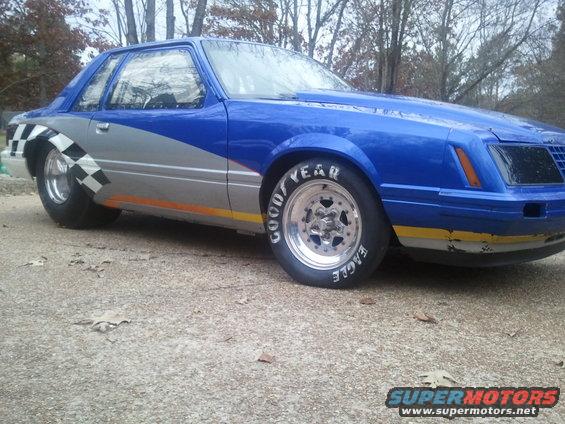 Blue and silver drag car with checkerboard fender flare and Goodyear Eagle tires