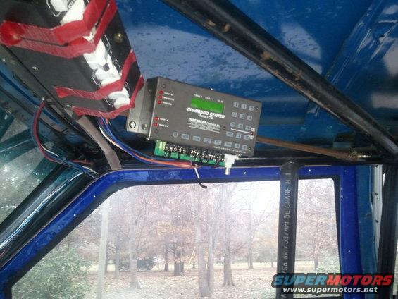 Interior view of a vehicle showing a 'COMMAND CENTER Model EC-3' unit mounted overhead with wiring