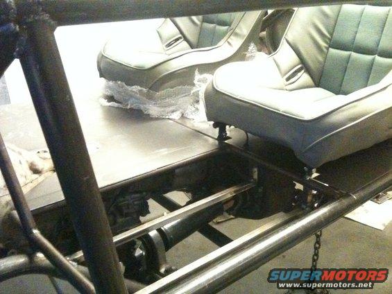 Interior view of a buggy with two grey bucket seats and roll cage