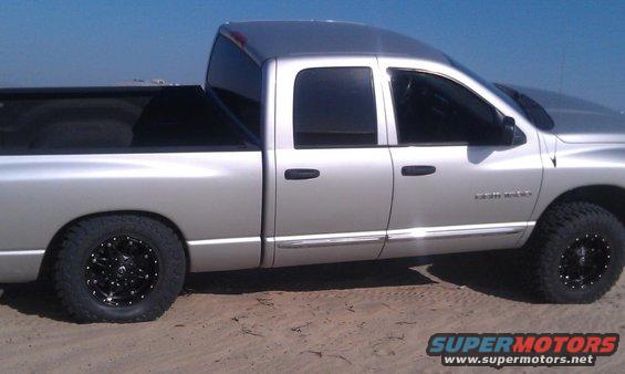 Silver 2005 Dodge 1500 pickup truck side view with black wheels
