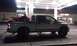 2005 Dodge 1500 - A silver pickup truck is parked at a gas station at night, with a red ATV loaded in the truck bed.