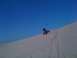 2005 Dodge 1500 - A quad bike rides down a sandy slope under a clear blue sky.
