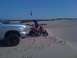 2005 Dodge 1500 - A silver pickup truck and a red ATV are parked on a sand dune under a clear blue sky.