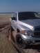 2005 Dodge 1500 - Silver pickup truck with aftermarket wheels on a sandy beach, ocean in background.
