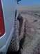 2005 Dodge 1500 - A silver pickup truck navigates sandy terrain, showing its side profile and aggressive tires.