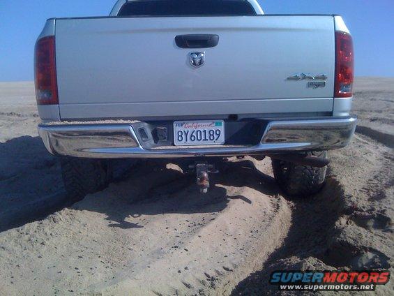 2005 Dodge 1500 pickup truck rear view in sand, California license plate 8Y60189