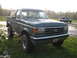 1990 Ford Bronco - A green 1990 Ford Bronco is parked in a grassy field with another vehicle in the background.