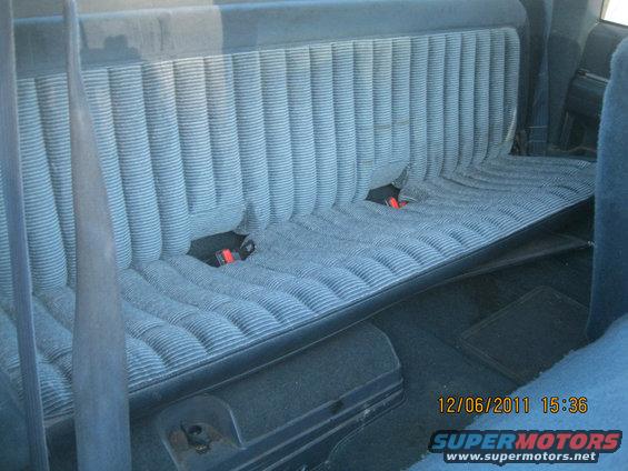 Blue striped bench seat with red seatbelts in a 1984 Chevrolet C/K Pickup