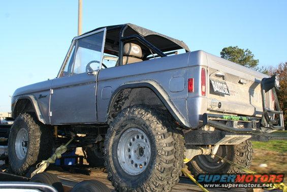 1982 Ford Bronco on a trailer, rear view, with a soft top and roll cage