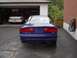 1993 Ford Probe - The rear of a blue 1993 Ford Probe GT is visible, with another white car in the garage behind it.