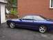 1993 Ford Probe - A blue coupe is parked in a driveway with a brick building in the background.