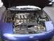 1993 Ford Probe - The engine bay of a blue 1993 Ford Probe is shown with the hood raised.