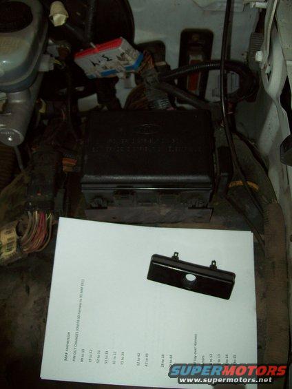 Engine bay with black fuse box, wiring, and a document titled MAF conversion