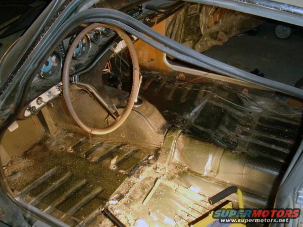 1969 Volvo P1800 interior, showing stripped floor, dashboard, and steering wheel