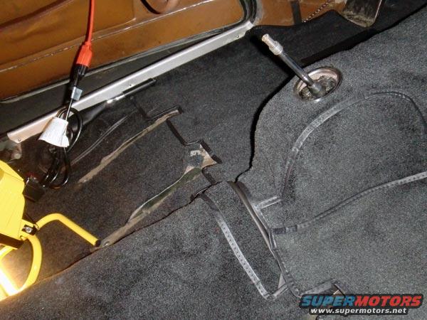 1969 Volvo P1800 interior showing black carpet, gear shifter, and brown door panel