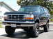 1995 Ford Bronco - This lifted Ford Bronco is shown from the front three-quarter view, highlighting its off-road tires and chrome accents.