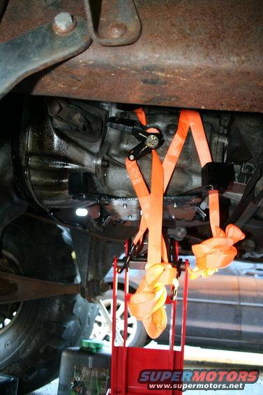 straps holding up a transmission during removal