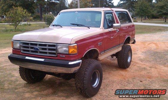 Two-tone red and tan lifted 1987 Ford Bronco, 3q-front view