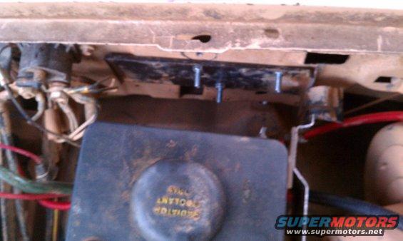 close-up of radiator overflow tank and wiring under vehicle