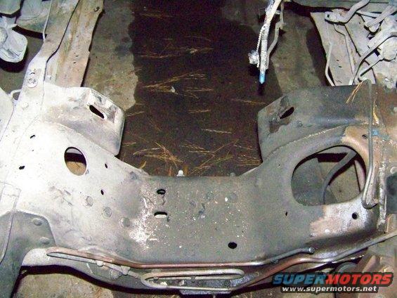close-up of vehicle frame, possibly from a truck or SUV, showing mounting points and some wiring