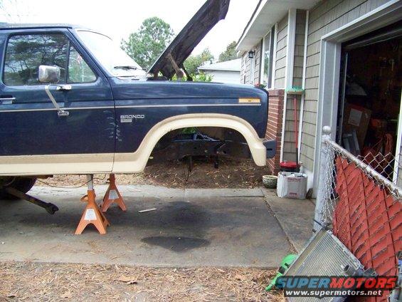 Blue Ford Bronco on jack stands with hood open, showing the engine bay