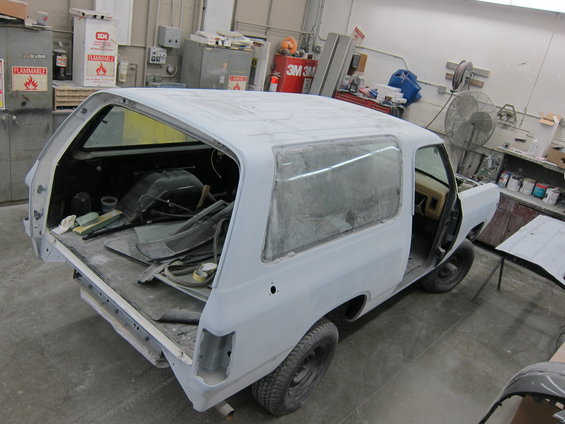 1987 Dodge Ramcharger body in primer, undergoing bodywork in a shop