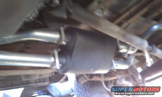 Underside view of a vehicle's exhaust system with a muffler and pipes