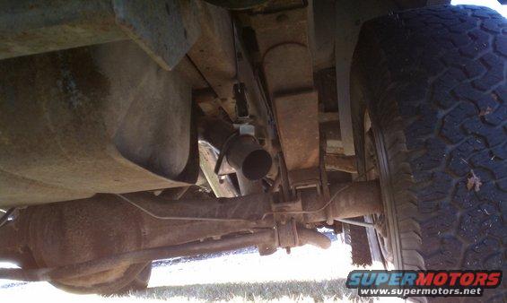 Undercarriage view of a vehicle's rear axle, fuel tank, and exhaust pipe